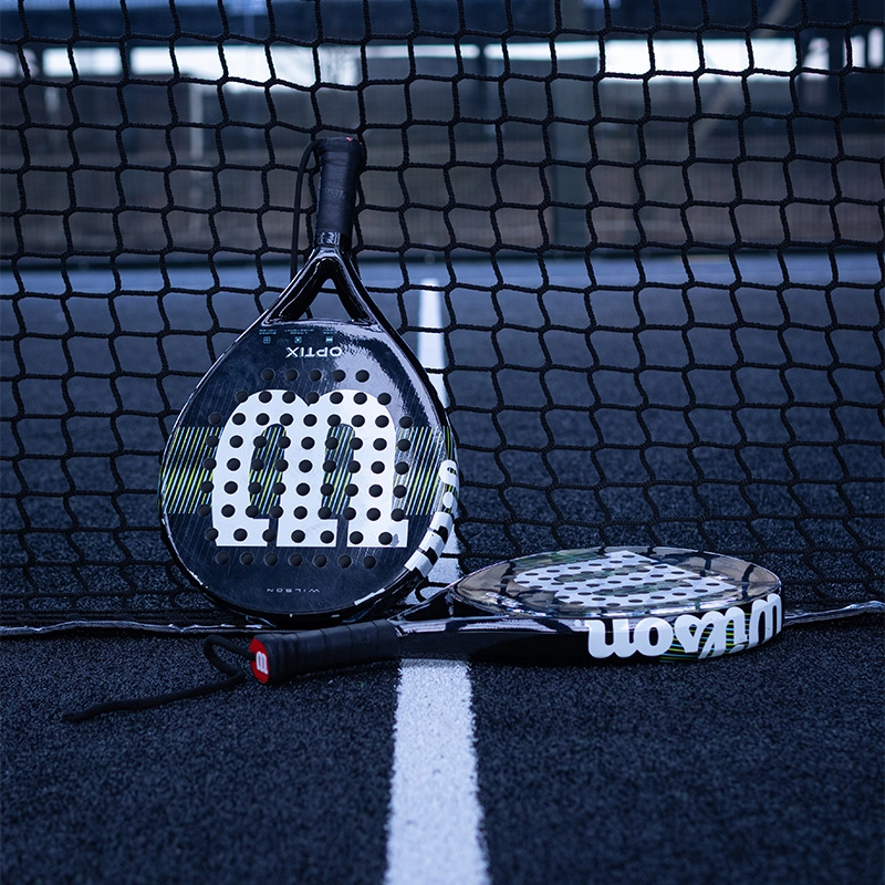 Two padel rackets leaning on net