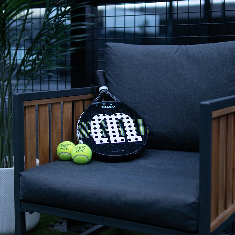 Racket and balls sitting on chair